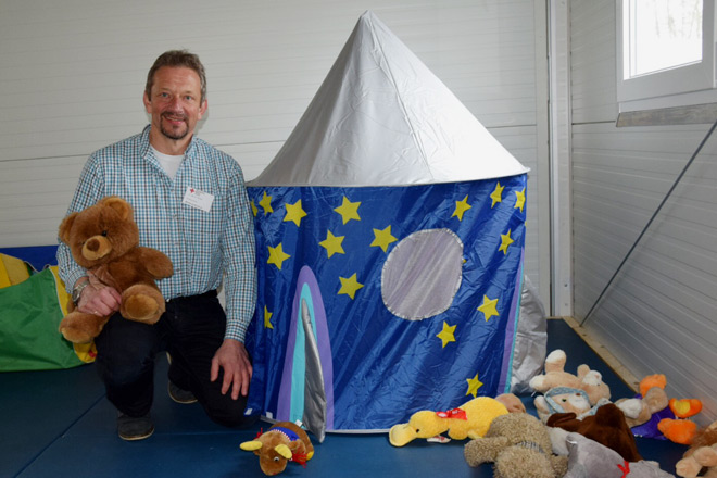 Erster Runder Tisch in Hörstel-Dreierwalde Betreuungsleiter Manfred Eichert mit einem Teddybär im Kinderbetreuungsbereich.
