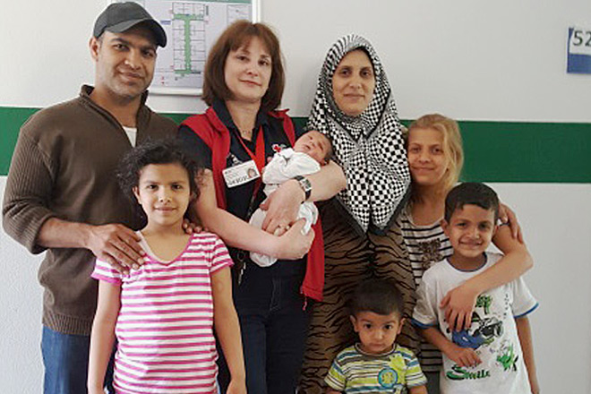 Herzlich willkommen: Ein Baby in Kerken-Stenden! Gruppenfoto: Die glückliche Familie mit Baby Hassan auf dem Arm seiner spontanen Geburtshelferin.