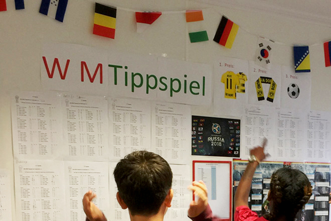 Selm im WM-Fieber Aushang: Die Ergebnis-Liste des WM-Tippspiels, davor zwei Personen, die die Liste anschauen.
