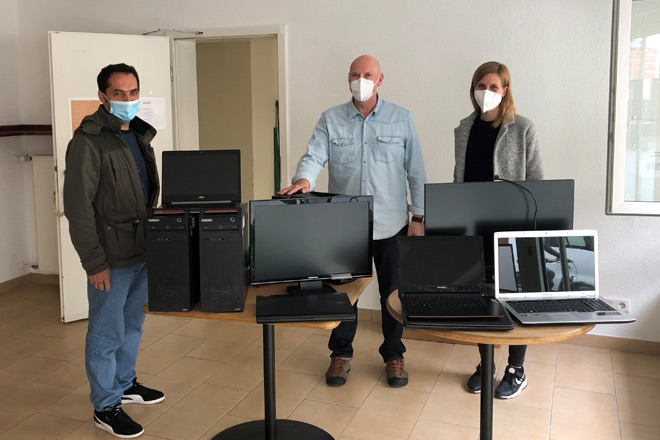 Neue Rechner bieten eine Perspektive auch in Zeiten der Pandemie Drei Personen stehen hinter einem Tisch mit drei PC und fünf Laptops.