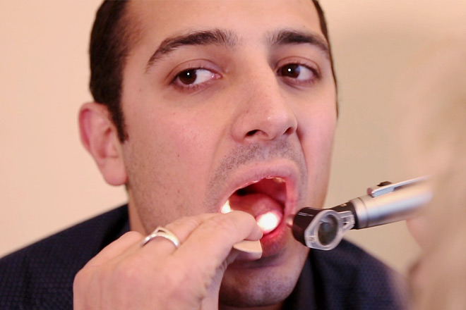 Nahaufnahme eines Patienten, dessen Mund und Hals untersucht werden.
