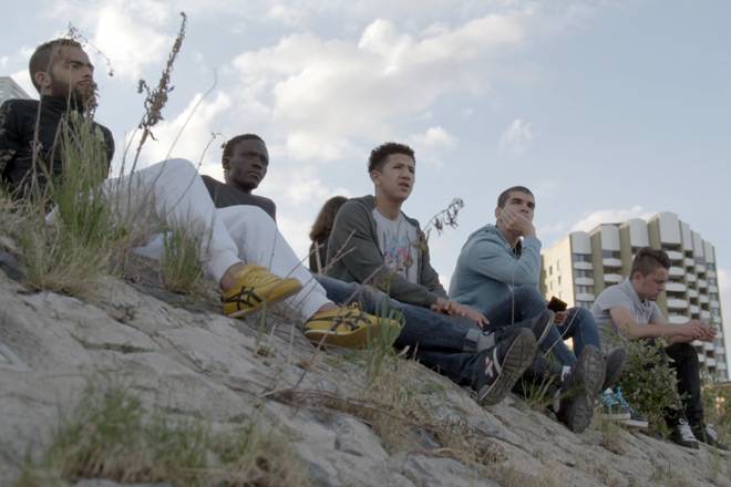 Fünf junge Männer sitzen am Rheinufer