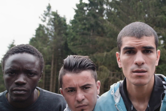 Drei junge Männer unterschiedlicher ethnischer Herkunft schauen in die Kamera.