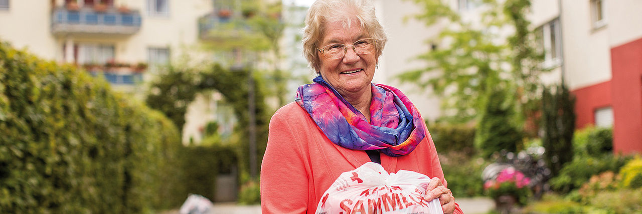Seniorin mit DRK-Kleiderspendenbeutel in der Hand