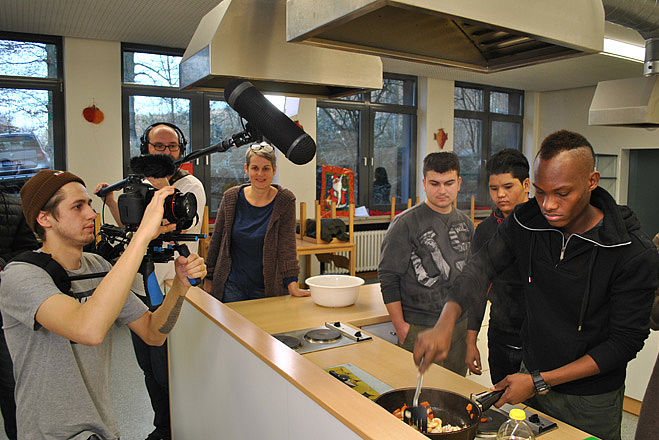 Ein Filmteam macht Aufnahmen von Jugendlichen, die etwas kochen